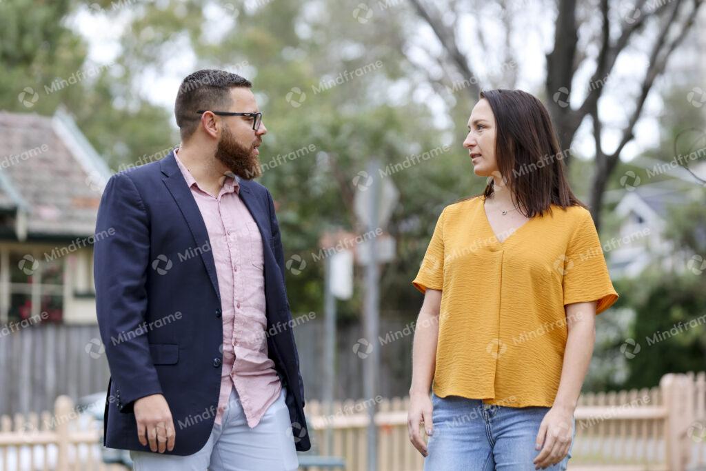 Two people standing and talking on street – Mindframe online image
