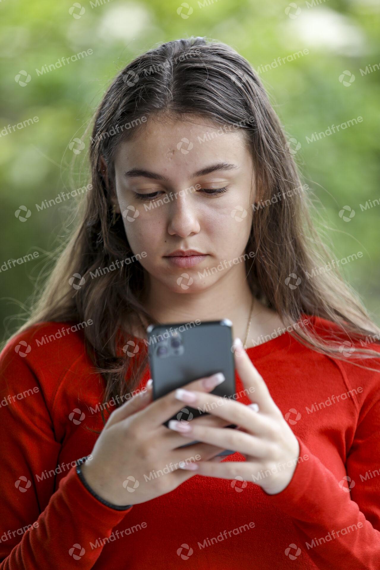 Young Person Using Mobile Sitting On Chair Mindframe Online Image young-person-using-mobile-sitting-on-chair-mindframe-online-image