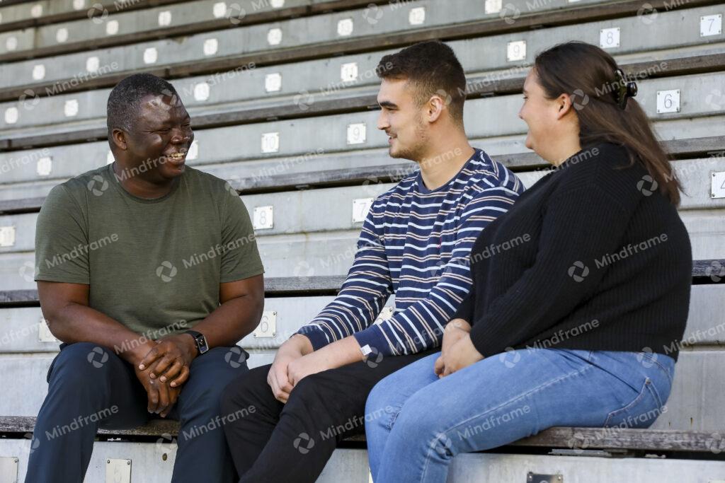 Three people talking, sitting on a bench – Mindframe online image ...