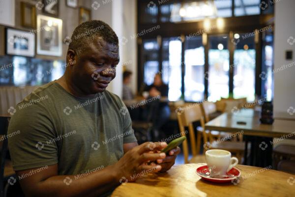 Person sitting in a café on his phone