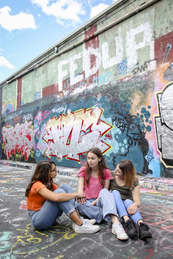 Group of young women sitting outside in lane talking