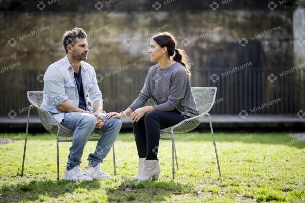 Two people sitting, talking in a garden