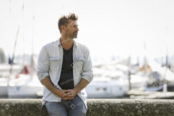 One person, standing by a marina