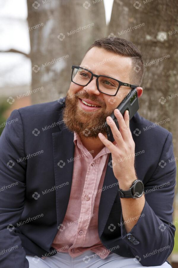 One person on the phone in front of tree