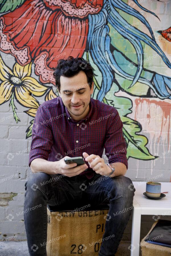 Person sitting down using his phone at a café